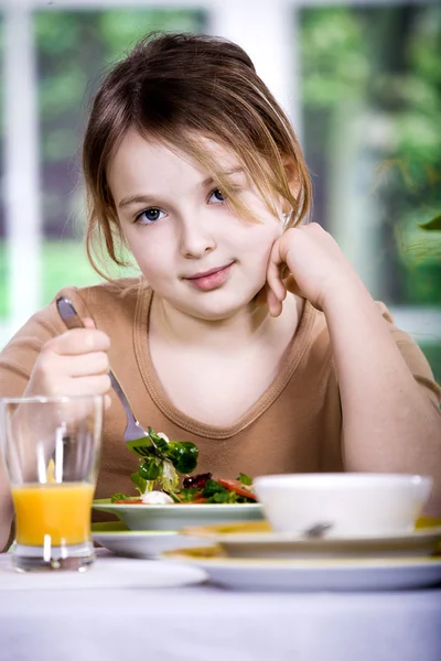 집에서 샐러드를 먹는 어린 소녀. 스튜디오 촬영 — 스톡 사진