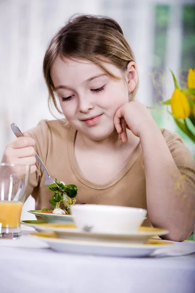 Dziewczynka jedzenie sałatka w domu. strzelać studio — Zdjęcie stockowe