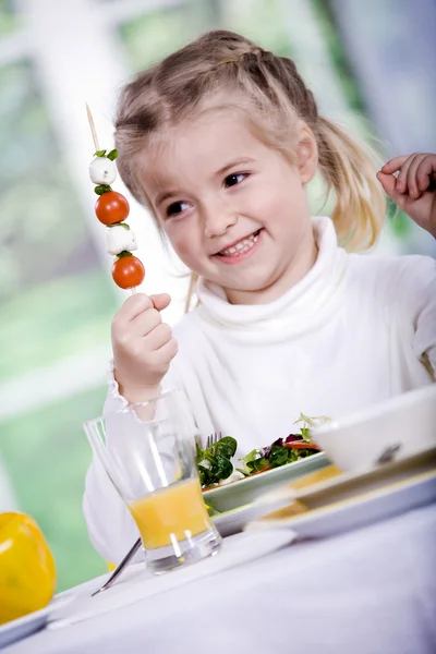 Giovane ragazza che mangia insalata a casa. Un servizio in studio — Foto Stock