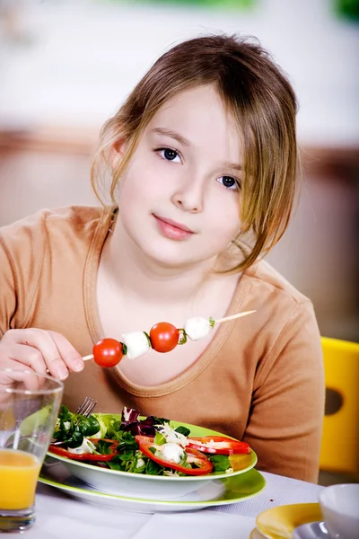 年轻的女孩在家里吃沙拉。工作室拍摄 — 图库照片