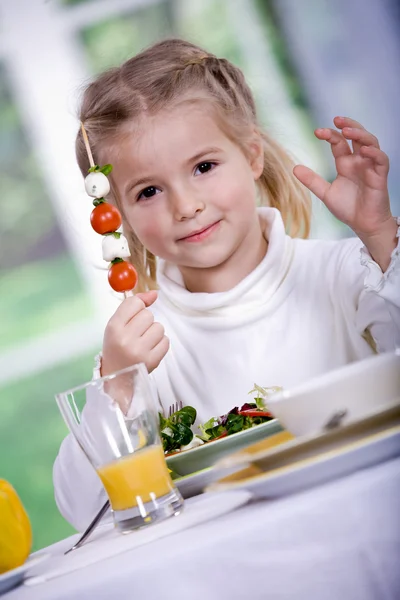 Young girl eating salad at home. A studio shoot Royalty Free Stock Images