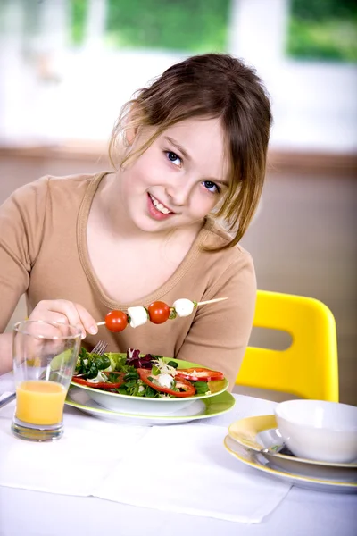Young girl eating salad at home. A studio shoot Stock Photo
