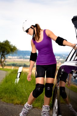 Young woman on rollerblades in the country clipart