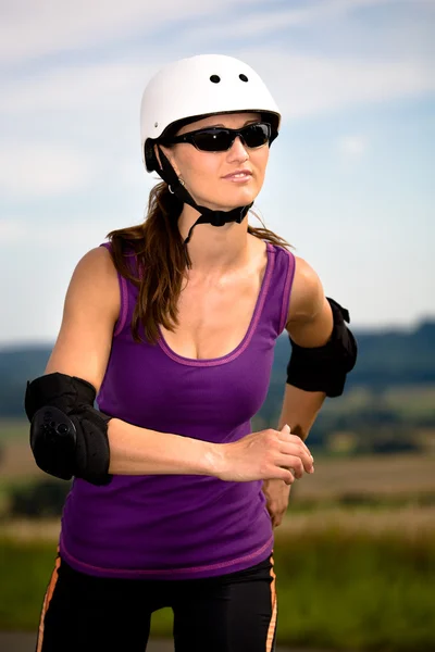 Young woman on rollerblades in the country — Stock Photo, Image