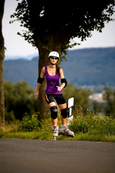 Mujer joven en patines en el país — Foto de Stock