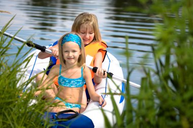 Two young girls at a lake clipart