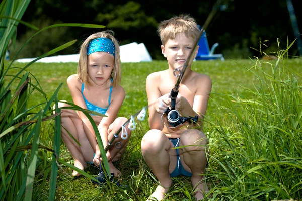 Ung flicka och pojke fiske — Stockfoto