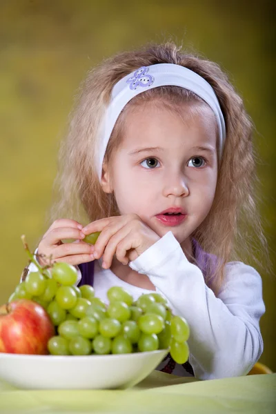 Девушка ест виноград — стоковое фото