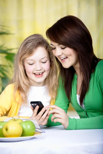 Twee meisjes met een mobiele telefoon — Stockfoto