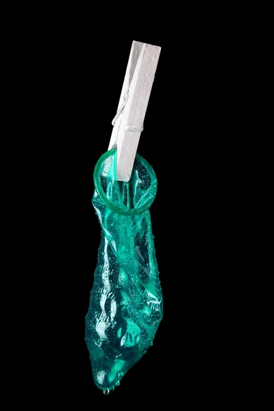 Green Condom with water drops in black background — Stock Photo, Image