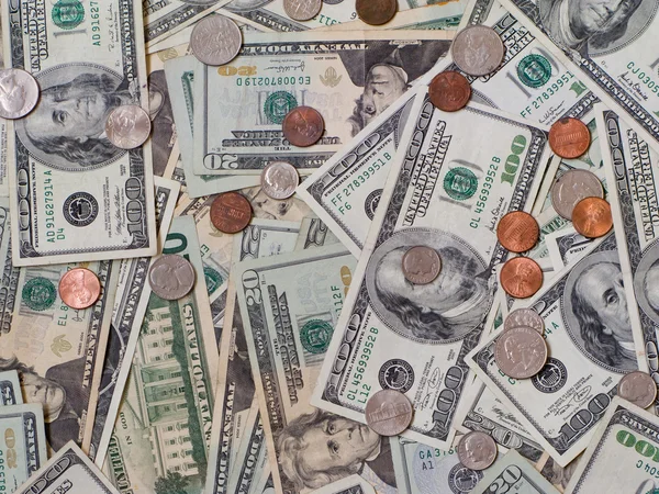 Dollarbiljetten opgestapeld met munten — Stockfoto