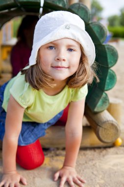 Girl playing on children's playground clipart