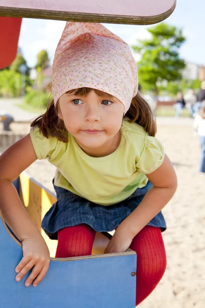 Small girl playing in children's playground — Stock Photo, Image