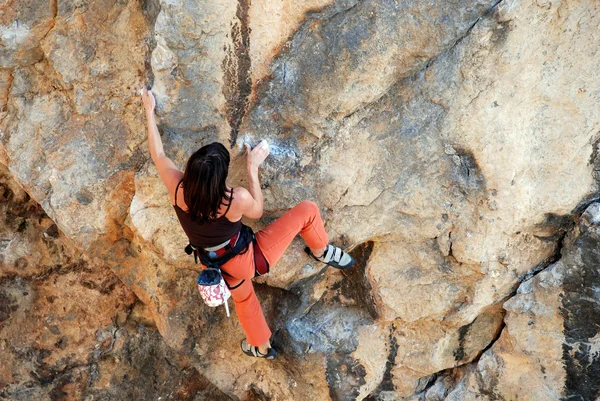 Молодая женщина во время завоевания скал — стоковое фото