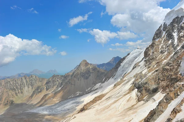 Κορυφή του ψηλά βουνά, σκεπάζεται από τα χιόνια. — Φωτογραφία Αρχείου