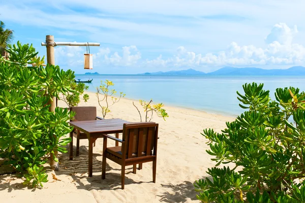 Стулья и стол на пляже у моря — стоковое фото