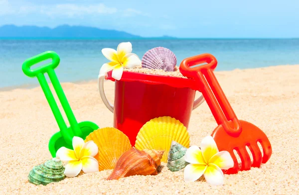 Лопата и другие игрушки на тропическом пляже — стоковое фото