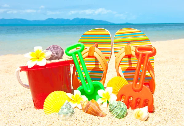 Лопата и другие игрушки на тропическом пляже — стоковое фото