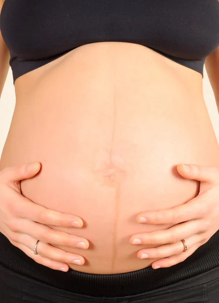 妊娠中の女性の腹を抱きしめる — ストック写真