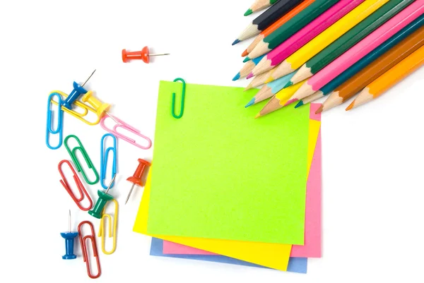 Цветной карандаш, зажимы и бумага для заметок на белом — стоковое фото