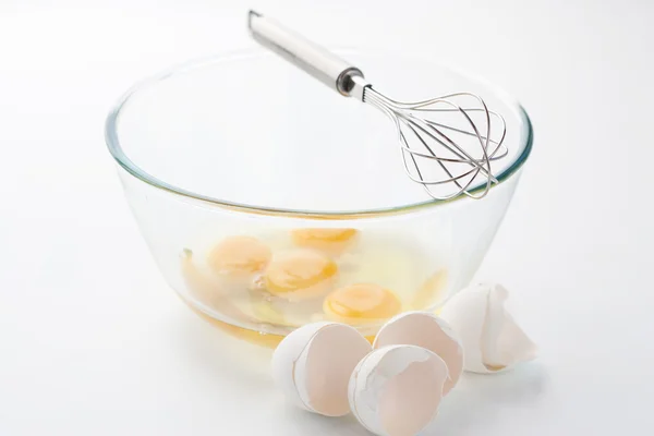 Whisk with eggs in a bowl — Stock Photo, Image