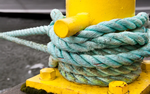 stock image Twisted green rope around a yellow pier