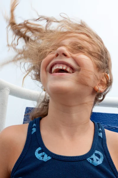 可爱的小女孩，她的头发吹在风中笑. — 图库照片