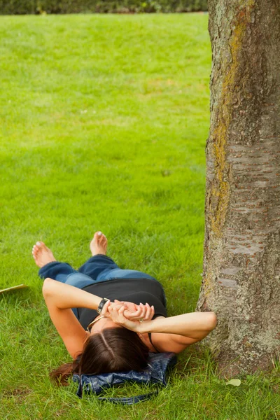 stock image Female relaxing on the lawn in the park.