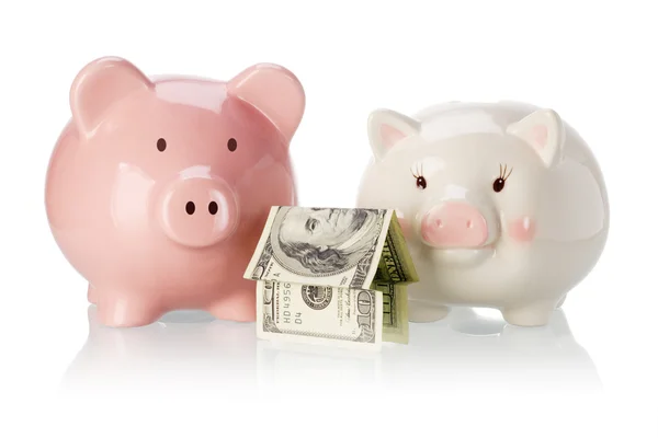 Pair of piggy banks with money house — Stock Photo, Image