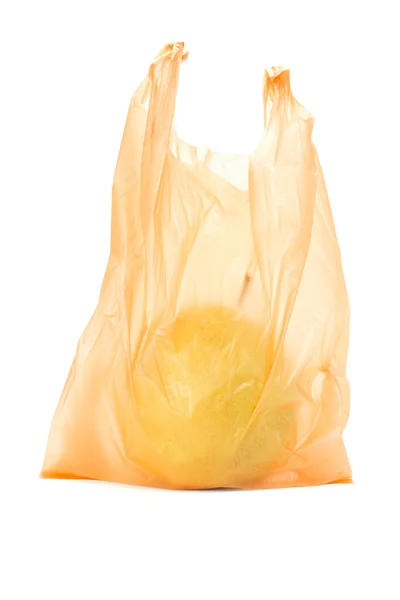 Желтая груша в оранжевом пластиковом пакете — стоковое фото