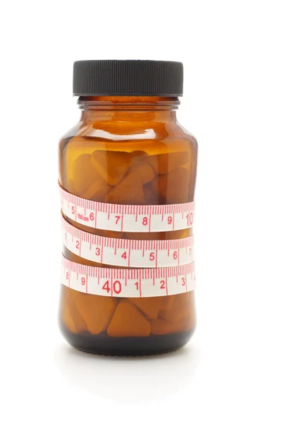 Tape measure and diet pills in glass bottle — Stock Photo, Image