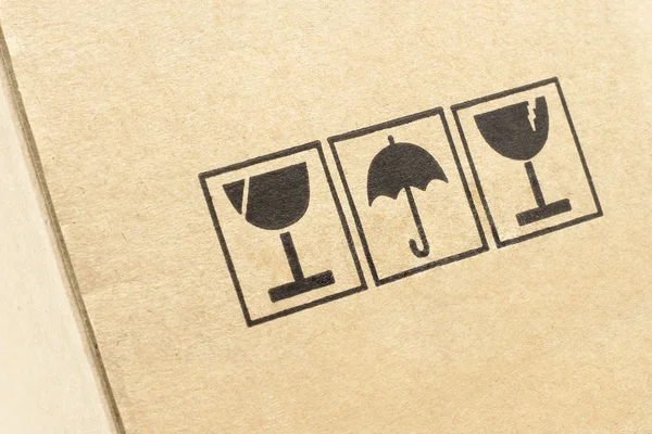 Símbolos de precaución en caja de cartón — Foto de Stock
