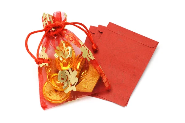 Gold ingots and coins in decorative sachet and red packets — Stock Photo, Image