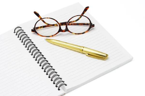 Pen and eyeglasses on a notebook — Zdjęcie stockowe