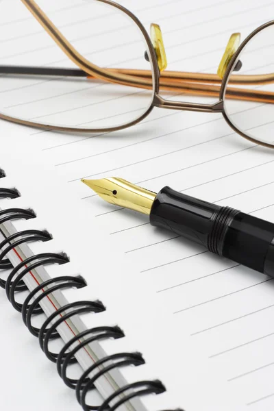 Óculos e caneta-tinteiro no caderno — Fotografia de Stock