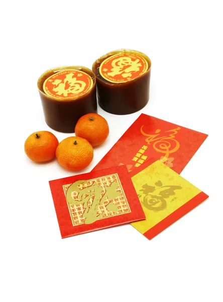 Čínský Nový rok rýžové koláčky, pomeranče a červená pakety — Stock fotografie