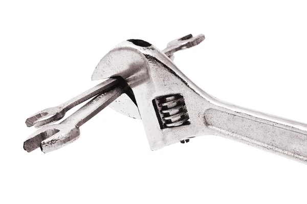 Adjustable wrench gripping a pair of spanners — Stock Photo, Image