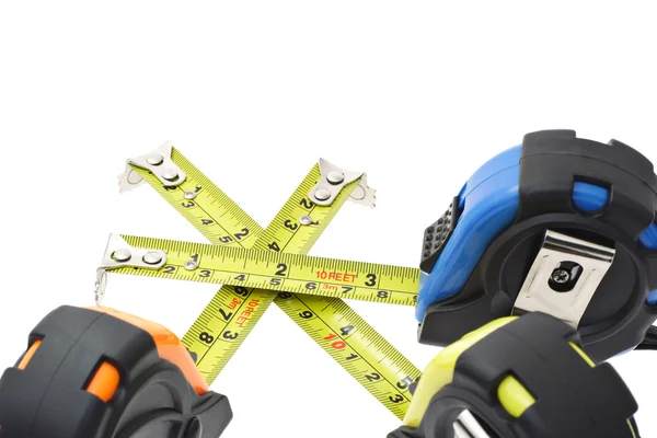 Measuring tapes criss crossing — Stock Photo, Image