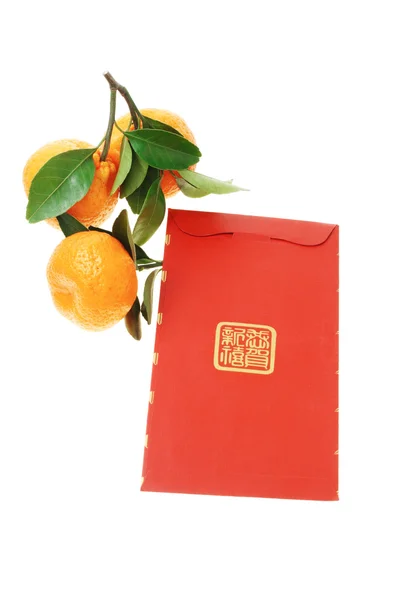 Kinesiska röda paket och mandarin apelsiner — Stockfoto