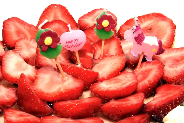 草莓生日蛋糕上的四个幼稚蜡烛 免版税图库照片