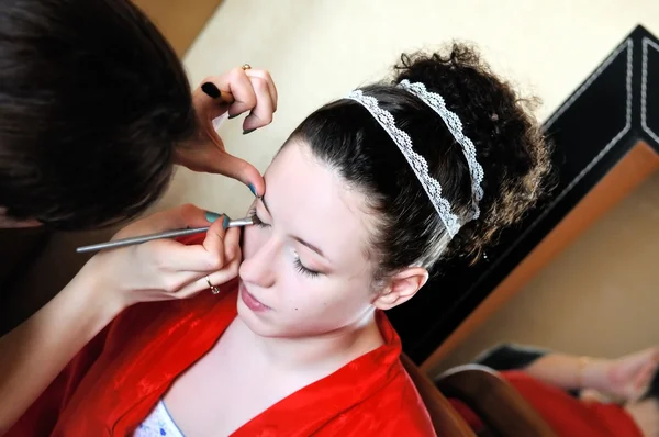Bruden tillämpa bröllop make-up av make-up artist — Stockfoto