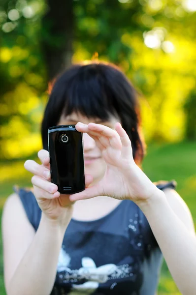 Woman taking photo using her mobile phone — Zdjęcie stockowe