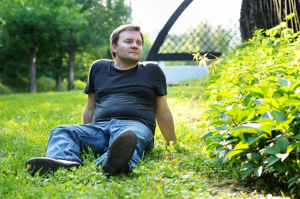 Man sitter på gräset — Stockfoto