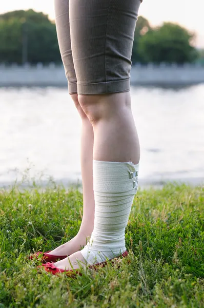 Una mujer con vendaje en la pierna lesionada — Foto de Stock