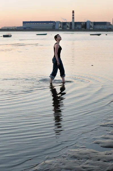 Kale vrouw lopen door het water — Stockfoto