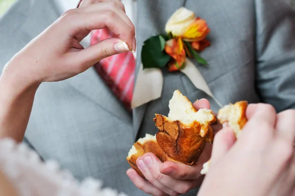 新郎結婚式伝統的な丸いパンのスライスを保持 — ストック写真