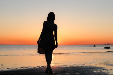 vrouw als silhouet door de zee