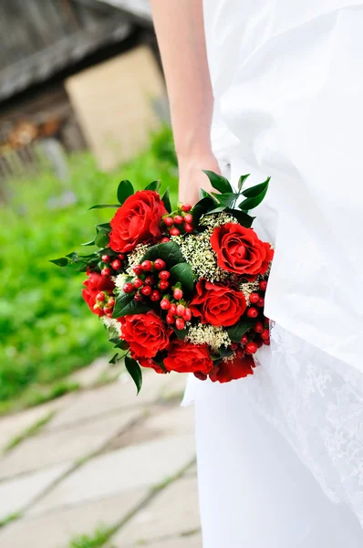 Novia sosteniendo flores rojas de la boda ramo — Foto de Stock