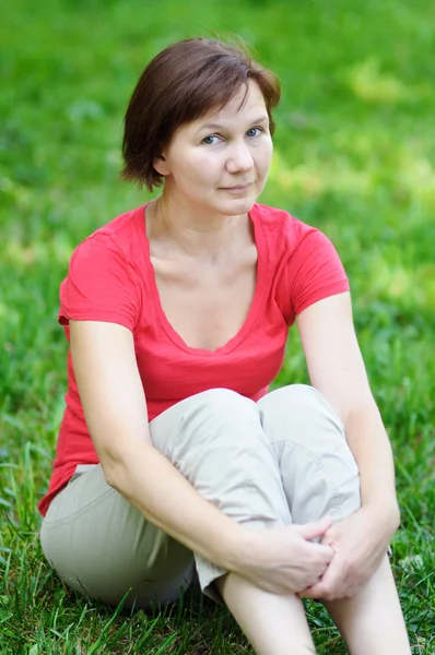 Женщина сидит в парке — стоковое фото