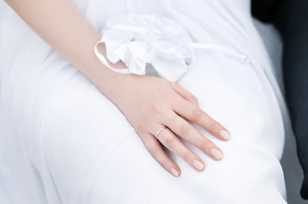 新娘的手躺在一条白色的裙子 — 图库照片